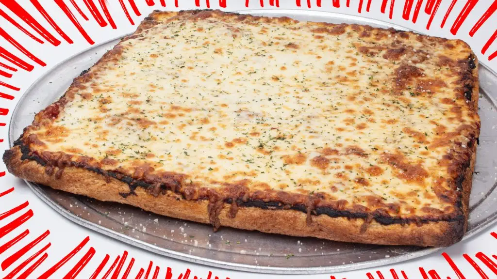 Whole Sicilian-style cheese pizza with a thick, square crust, melted mozzarella, tomato sauce, and Italian herbs, served on a round metal pizza tray against a white background with decorative red accent lines.
